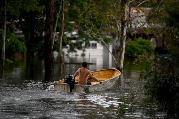 Jayden Evans uses his boat to access his home and property which is cut off by flood water at South Windsor in Sydney’s north-west on Thursday.