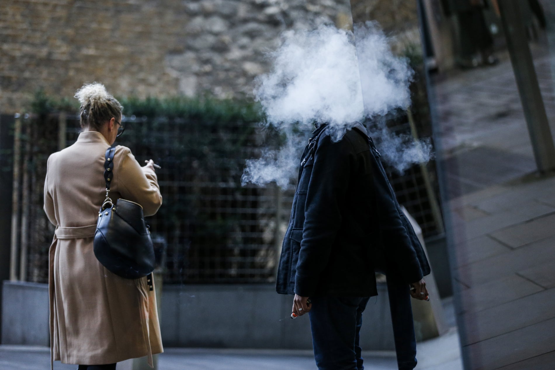 a smoker and a person vaping in london, uk