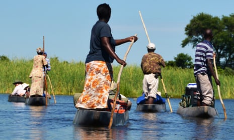 Boats men women pole river delta Botswana