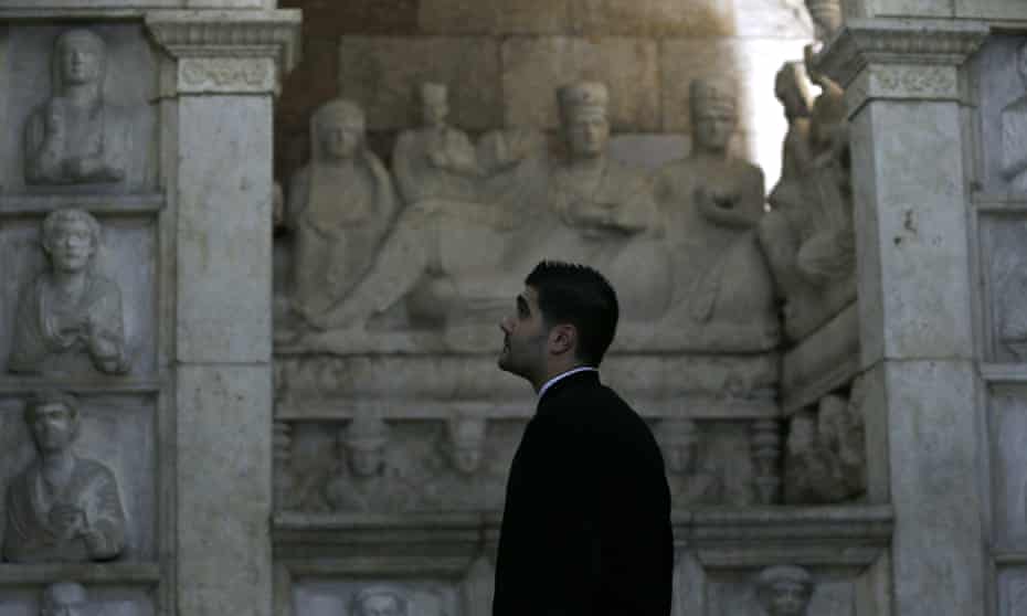 A priest visits the National Museum in Damascus as it reopens one wing