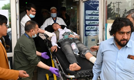 Medical staff move an injured person on a stretcher inside a hospital after two bomb blasts at a boys' school in a Shia Hazara neighbourhood in Kabul