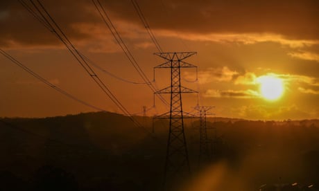 Sun sets behind transmission wires and towers