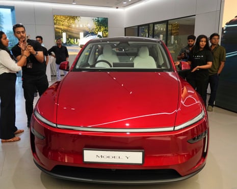 Media personnel look at the refreshed Tesla Model Y electric car at the newly opened Tesla showroom in Mumbai, India.
