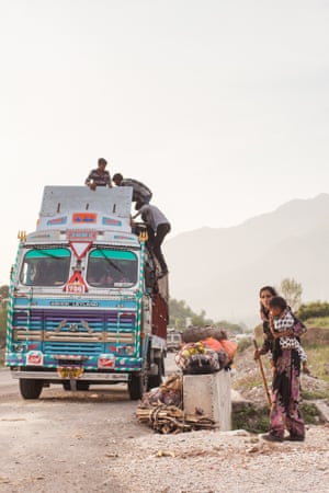 A nomadic family lift their belongings on to a truck