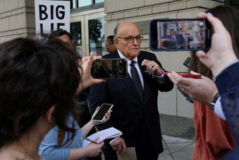 Giuliani speaks to people outside a courthouse.