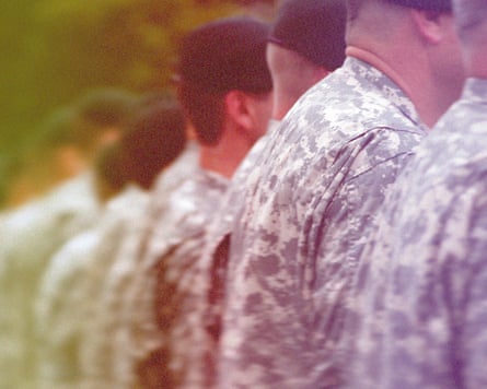Line of soldiers in camouflage uniforms, viewed from behind, slightly out of focus