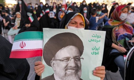 A woman holds a poster of Ebrahim Raisi, with text in Persian reading ‘government of the people, strong Iran’, as supporters celebrate his victory in Tehran.