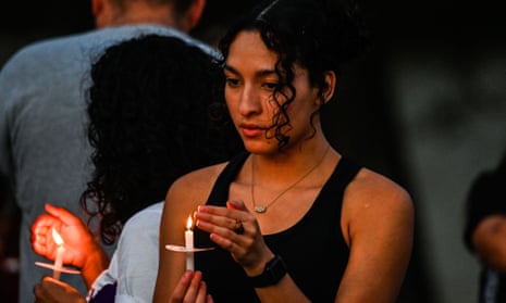A young woman holds a candle at a vigil on Monday for the victims of the mass shooting in Uvalde, Texas.