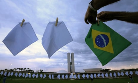 White scarves representing people who have died of Covid-19 in Brazil are hung over a field in Brasilia.