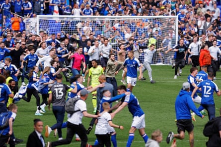 Fans and players run onto the pitch at the final whistle to celebrate Ipswich Town’s promotion to the Premier League.