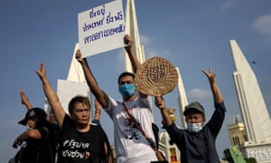 Protesters hold a sign reading, “The longer you stay, the more devastation to the country, please resign” as they take part in an anti-government demonstration in Bangkok on July 18, 2020.