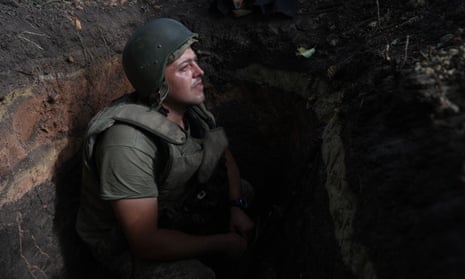 A Ukrainian soldier sits in a foxhole at a position along the front line in the Donetsk region in eastern Ukraine on 15 August.