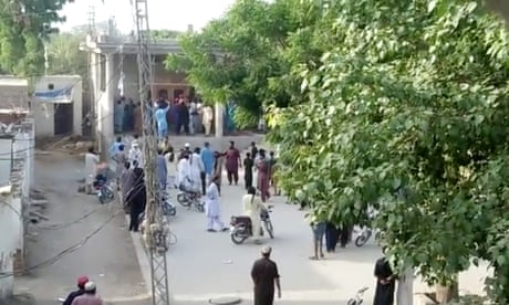 People gather outside a Hindu temple that was set on fire by a mob after reports that a Hindu boy had urinated in the library of an Islamic seminary, in Bhong, Pakistan 4 August 2021.