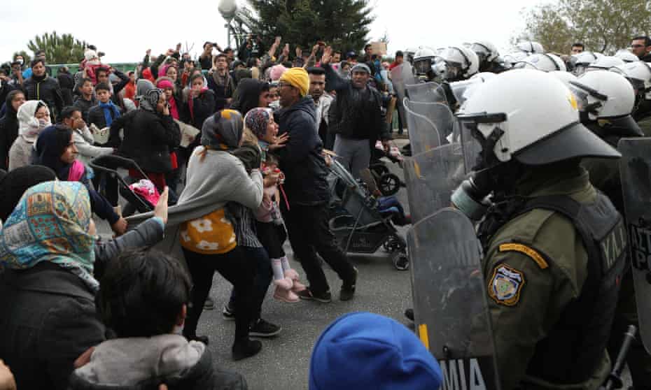 Refugees and migrants confront riot police