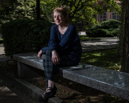 Cattaneo seated on a stone bench under trees in an urban park