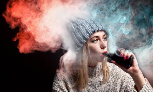 A young woman smoking an e-cigarette.