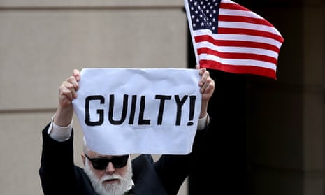 A lone protester holds up a sign and American flag outside the courthouse in Alexandria, Virginia, after the former Trump campaign chairman Paul Manafort was found guilty on eight counts of fraud.