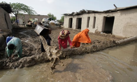 Villagers clear flood water from their houses in Jhado near Hyderabad, Pakistan