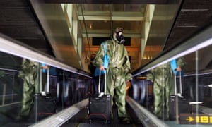 A passenger wearing protective garments arrives at the Josep Tarradellas Barcelona-El Prat Airport from London.