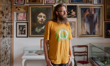 Steffen Geyer standing in front of a wall full of paintings in the Hemp Museum in Berlin