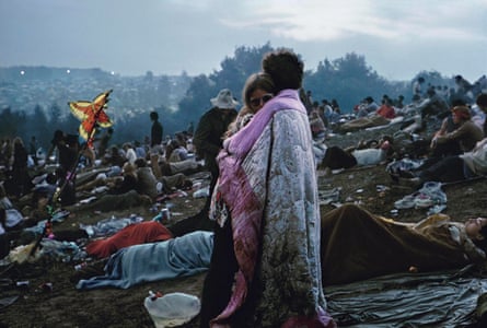 A couple wrapped in a blanket in front of crowds at Woodstock, 1969