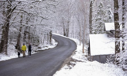 Peter and Joanna Brown walk their dog in West Paris, Maine, on Saturday.