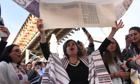 A woman holding a portion of the Torah during the morning prayer service at the Western Wall, in Jerusalem.