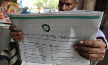 Man reading newspaper with full-page WhatsApp ad