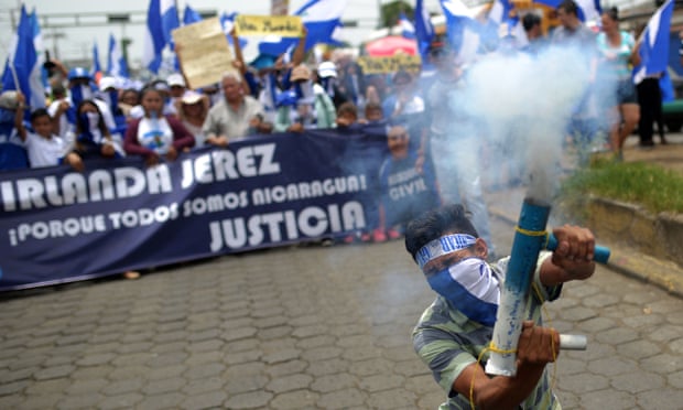 An anti-government demonstrator fires a home-made mortar as he takes part in a march demanding the resignation of Nicaraguan President Daniel Ortega and his wife