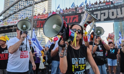 Protesters shout into megaphones as other protesters follow behind