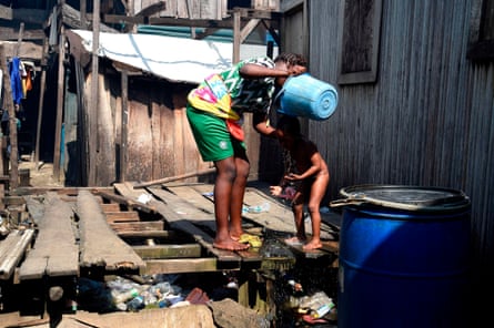 A woman washes her child in the Makoko riverine slum settlement in Lagos, November 2020