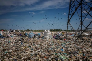 Families work in a rubbish dump encroaching on a wetland in an industrial district in Chennai