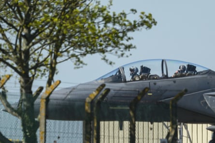 A pilot in the cockpit of a fighter plane on the ground at RAF Lakenheath
