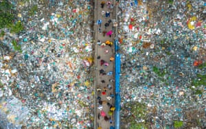 a drone shot of a bridge surrounded by plastic waste in Dhaka, Bangladesh