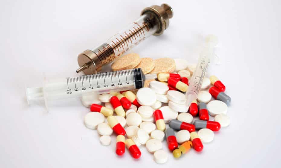 Various pills, tablets and capsules with various syringes, made of glass and plastic