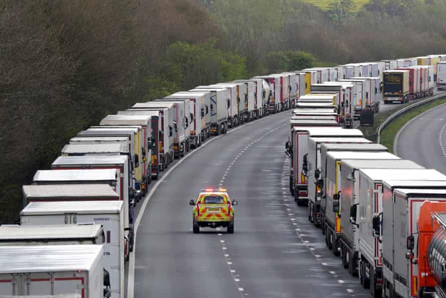 A police car passes lorries queued in Operation Brock.