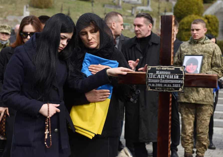Ukrainian soldiers and relatives attend a ceremony at the funeral of the soldier Teodor Osadchyi, killed during the Russian invasion, at Lychakiv cemetery in Lviv, western Ukraine.