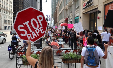 A woman holds a sign reading 'Stop Rape' as people gather to protest sexual assault, migrant policy and police brutality at Jane Bryne Park, located near the Michigan Avenue, in Chicago,