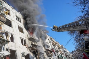 Ukrainian firefighters try to extinguish a fire after an airstrike hit an apartment complex in Chuhuiv, Kharkiv Oblast, Ukraine