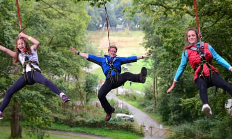 The Manchester Treetop Trek will be similar to this one in Windermere. Image shows guide and two children in harnesses enjoying a tree trek.