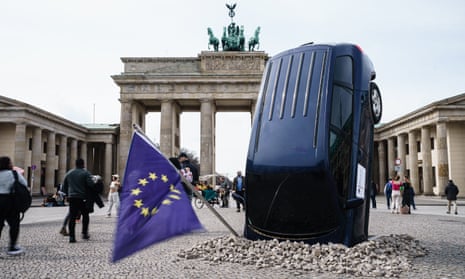 A Greenpeace installation of an SUV in the ground next to the Brandenburg Gate, Berlin, 22 March 2023.
