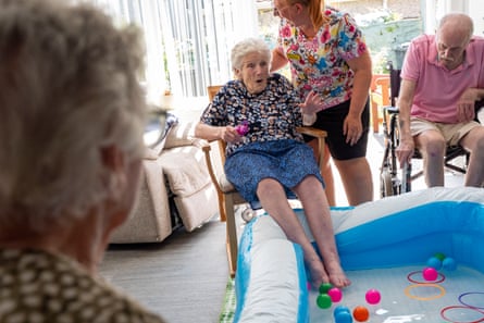 A care-home resident dips her feet in a cold paddling pool in Ebbw Vale, south Wales.