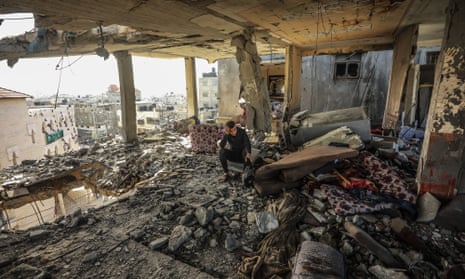 A Palestinian man sits amid a damaged of his house after an Israeli strike in Rafah, southern Gaza Strip.