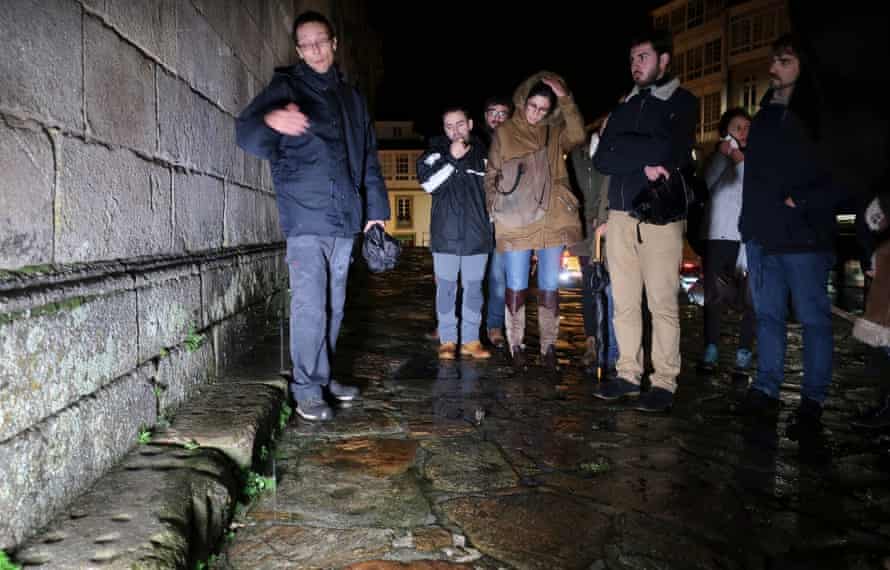 People watch crab games carved in stone in Santiago de Compostela