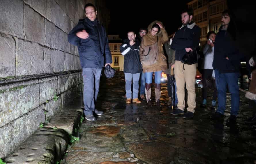 People look at games of noughts and crosses carved in stone in Santiago de Compostela