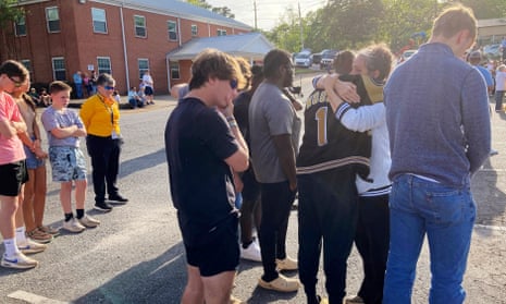 People embrace at a prayer vigil on 16 April 2023 outside First Baptist Church in Dadeville, Alabama, a day after a mass shooting at a teenager's birthday party.