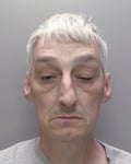 Mugshot of a white-haired man
