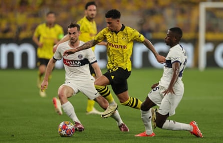 Borussia's Jadon Sancho skips past the challenges of Paris Saint-Germain Fabian Ruiz (left) and Nuno Mendes (right).