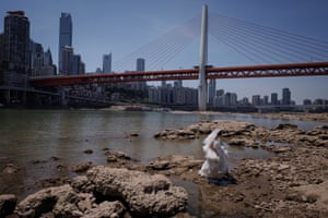 A woman in a wedding dress walks on the dried-up riverbed of the Jialing River in Chongqing, China