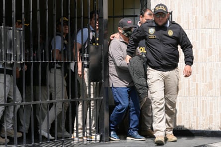 Police officers escort man out of home